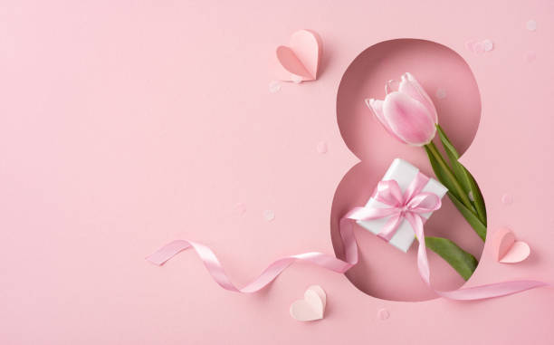 istock Elegant design with a tulip and gift on a pink backdrop for celebration 2198903996
