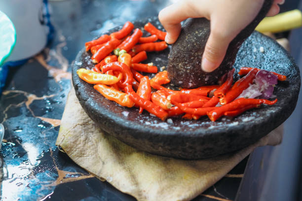 close up of hands grinding chili with a pestle