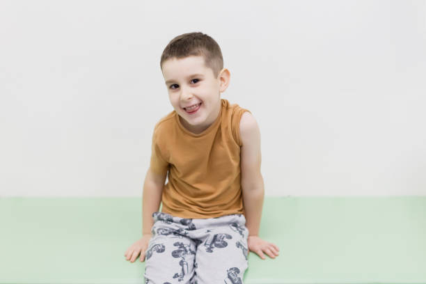 Caucasian smiling boy before vaccination sitting on a couch in clinic, copy space