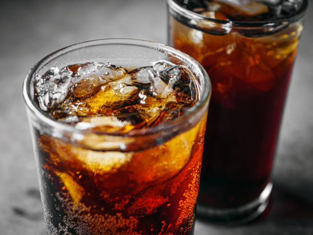 Cola soft drink with ice cubes, Close up of soda fizzy drink in Cold glass on gray background Cola soft drink with ice cubes, Close up of soda fizzy drink in Cold glass on gray background coca cola stock pictures, royalty-free photos & images