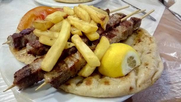 Juicy souvlaki skewers grilled over charcoal, served with warm pita bread and fresh lemon. A quick and delicious grab-and-go meal.