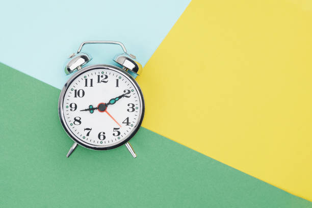 istock Alarm clock on colorful paper background 2198909263