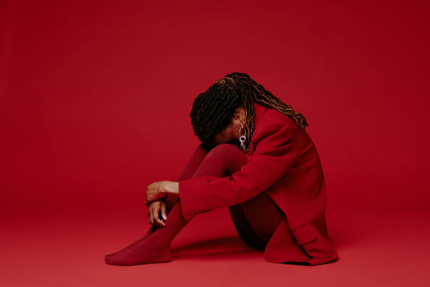 istock Sitting Woman Wearing Red against Matching Background 2198919950