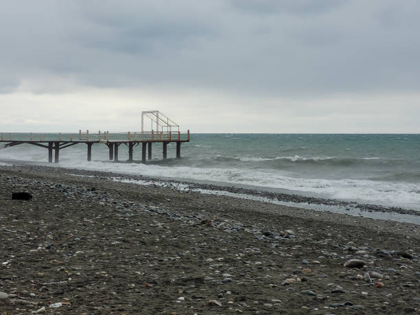 Powerful waves crashing onto a pebble beach in Batumi under a cloudy horizon, showcasing natural energy and the beauty of coastal landscapes.