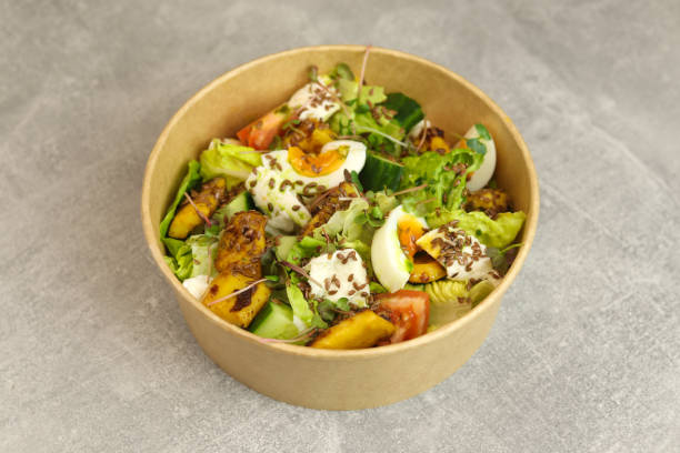 istock Healthy bowl with fried squid, egg, tomatoes, cucumbers, lettuce, cream cheese and flax seeds salad isolated on gray background. 2198924389