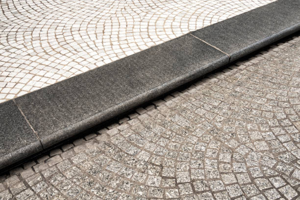 A large stone curve separating the street from the pavement in central Paris, France.