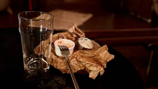 istock An Empty Dining Plate that has Leftover Food and Beverages Resting on a Table Surface 2198925384