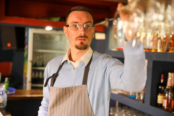 istock Bartender Picking Up a Glass at the Counter 2198925429