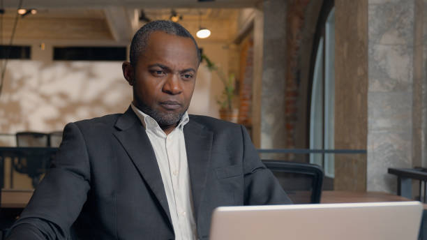 istock African American middle-aged entrepreneur typing laptop browsing computer writing report internet ethnic business man office businessman male guy working with pc online job work at table employer 2198926119