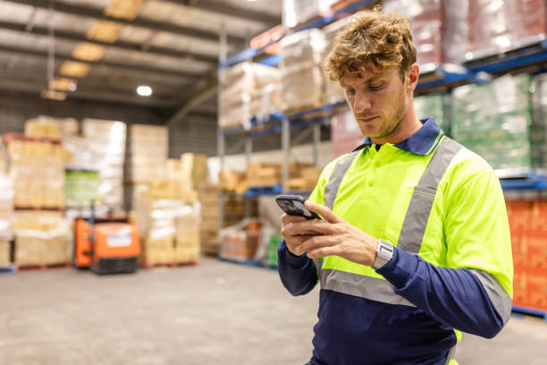 istock Men working in a distribution warehouse in Sydney, Australia, examining merchandise on a mobile device 2198928650