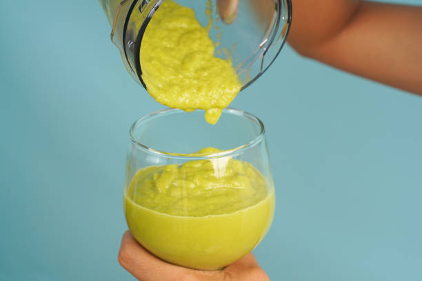 istock woman pours avocado smoothie into glass 2198928914