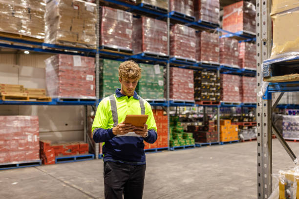 istock Men working in a distribution warehouse in Sydney while examining merchandise and utilizing technology for efficient shipping 2198929716