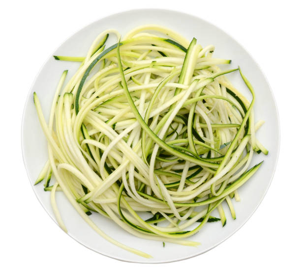 A pile of spaghetti zucchini slices on white