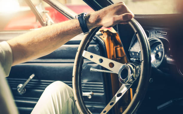 istock Classic Car Interior With Driver Gripping Steering Wheel at Dusk 2198929884