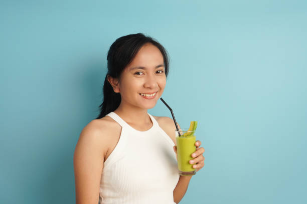 istock Refreshing Avocado Drink: Woman Sipping a Smoothie with a Straw 2198930105