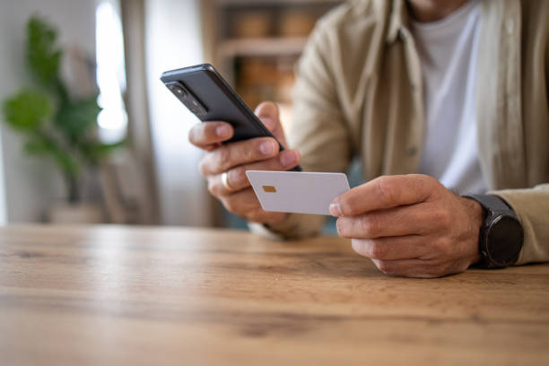 istock Man holding a payment card making an online purchase or checking account balances via electronic banking 2198931495