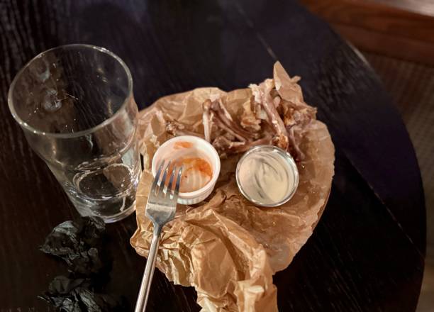 istock An Empty Dining Plate that has Leftover Food and Beverages Resting on a Table Surface 2198931727