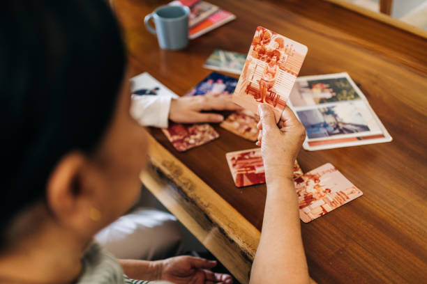 istock Nostalgic Moment as Senior Looks at Old Pictures for Memory Therapy 2198934793