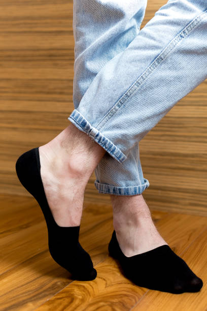 istock Man in stylish black short sock on light interior background, closeup.rear view, heel view 2198937642