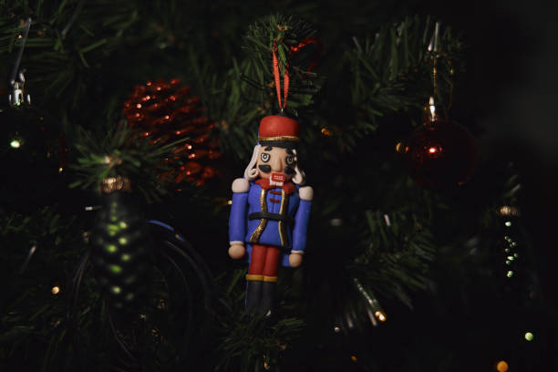 istock Nutcracker figurine hanging on the Christmas tree surrounded by lights and baubles 2198938887