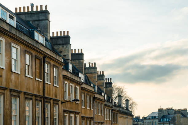 istock Rooftops and chimneys rising under a blue sky in bath, england 2198940369