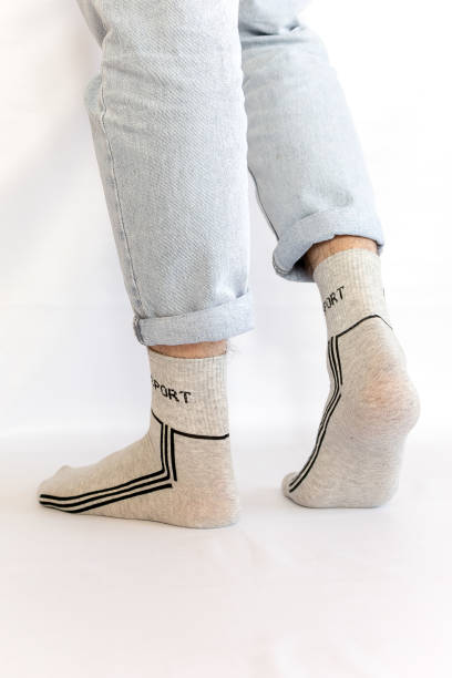 istock Man in stylish grey socks on light white background, closeup.rear view, heel view 2198940473