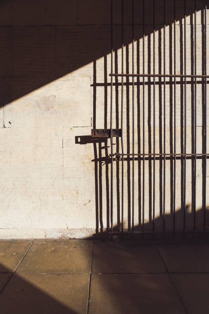 Sunlight illuminating a metal gate in a dark underpass in bath, england