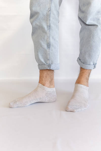 istock Men's legs in gray short socks on a white background 2198942398