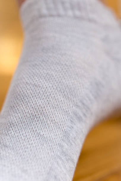 istock Men's legs in gray short socks on a background 2198943275