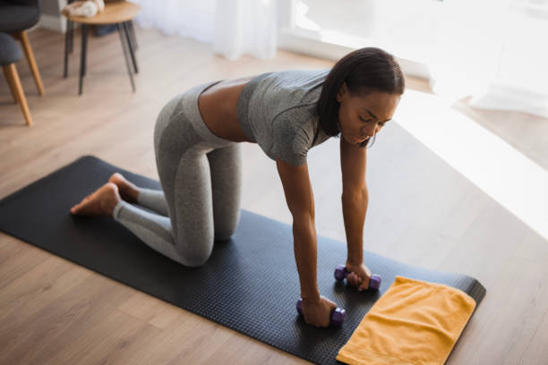 istock Female African Athlete exercising with weights 2198943684