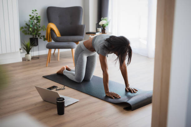 istock Fot black woman stretching her back during home workout 2198943974
