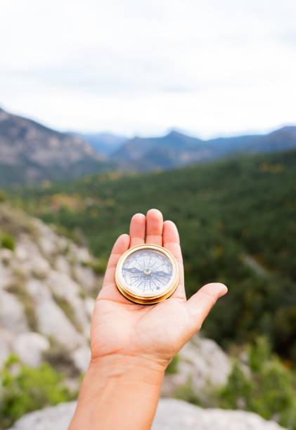 istock Hand gripping compass, navigating rugged mountain terrain, embodying adventurous exploration and wilderness spirit 2198944850