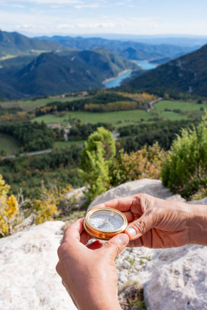 istock Hands holding compass, searching direction in mountain valley landscape during trekking adventure 2198944897