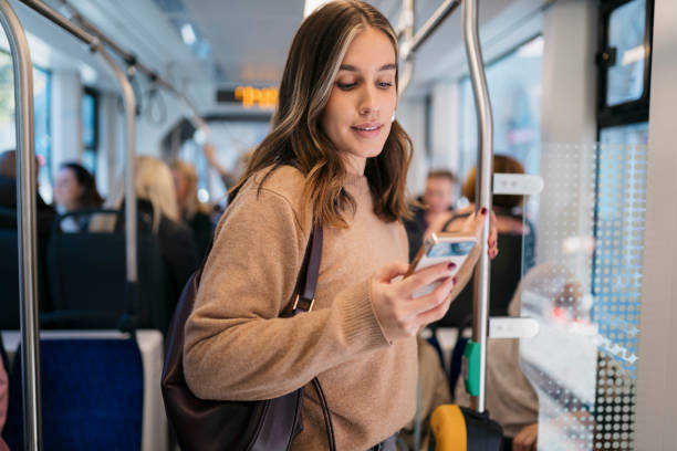 istock Young woman using smartphone while standing on public transport 2198944997
