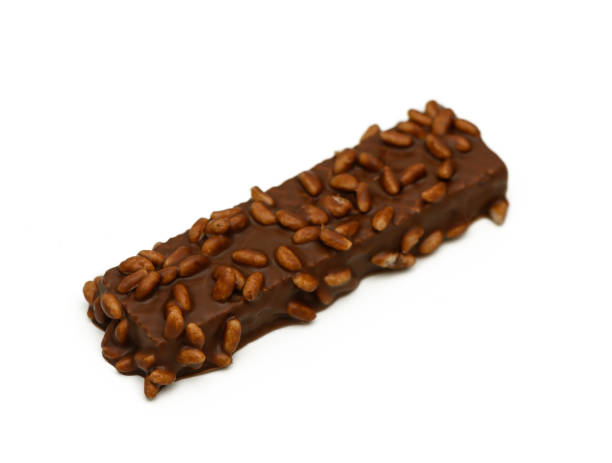 istock Decadent chocolate bar topped with crunchy seeds resting on a white background 2198950823