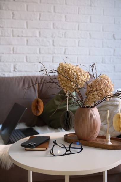 istock A beautifully cozy home workplace with modern easter home decor that includes vase with dry branches, flowers and eggs, notebook, mobile phone, glasses, candles on coffee table. 2198951424