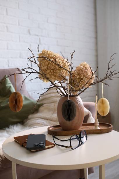 istock A beautifully cozy living room with modern easter home decor that includes vase with dry branches, flowers and eggs, notebook, mobile phone, glasses, candles on coffee table. 2198951775
