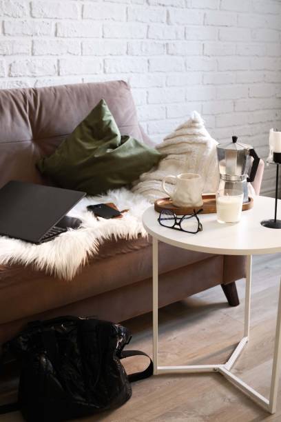 istock A Stylish and Functional Workspace Featuring a Laptop, mobile phone, notebook with glasses, books in bag on sofa and coffee break.. 2198951933
