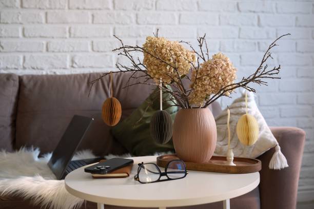 istock A beautifully cozy home workplace with modern easter home decor that includes vase with dry branches, flowers and eggs, notebook, mobile phone, glasses, candles on coffee table. 2198952397