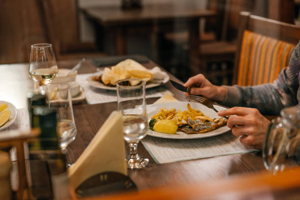 Person eating fish and polenta at restaurant