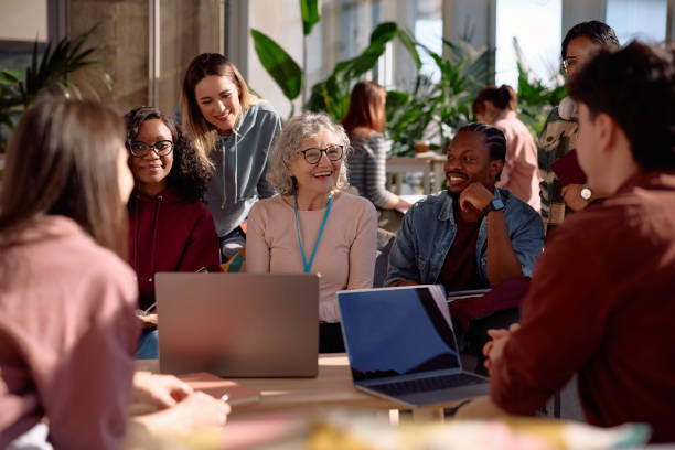 istock Group of happy students talking to their teacher while learning at campus. 2198962148