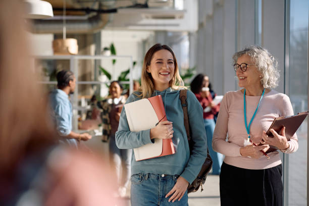 istock Happy student and her college teacher walking through the hallway. 2198962167