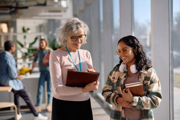 Happy university professor talking to Indian female student after a lecture.
