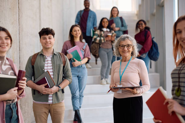 istock Happy professor and her students at the university looking at camera. 2198962208