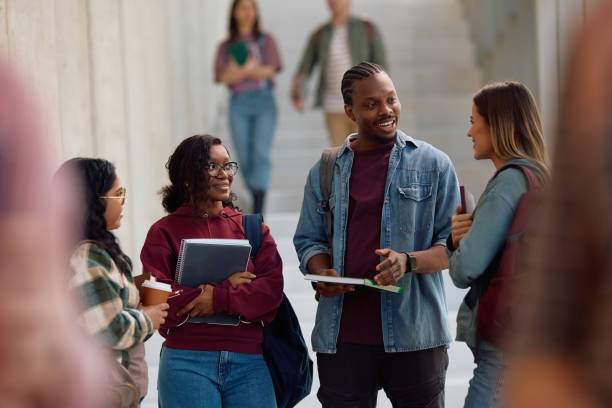 istock Happy college friends talking while standing in a hallway. 2198962213