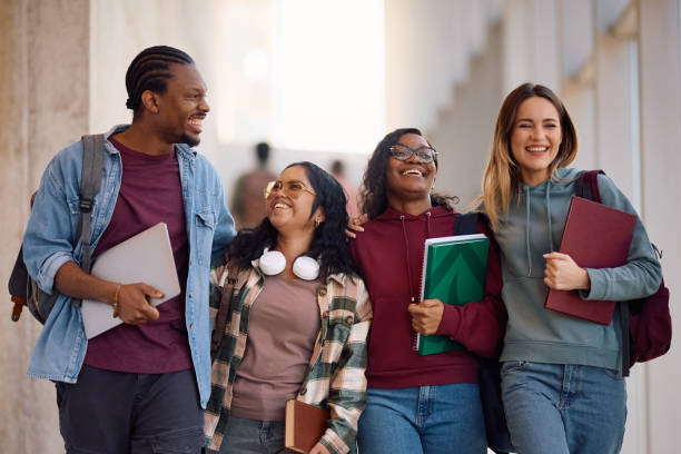istock Happy university friends walking embraced through the hallway. 2198962252