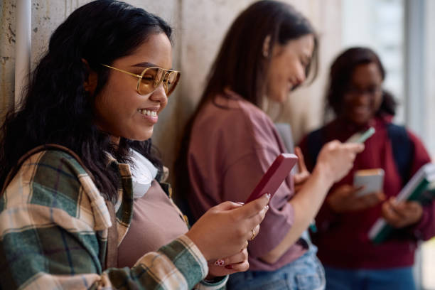 istock Happy Indian female student using cell phone in a hallway. 2198962268