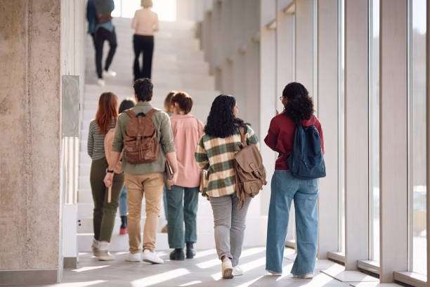 istock Rear view of college students walking in a hallway. 2198962307