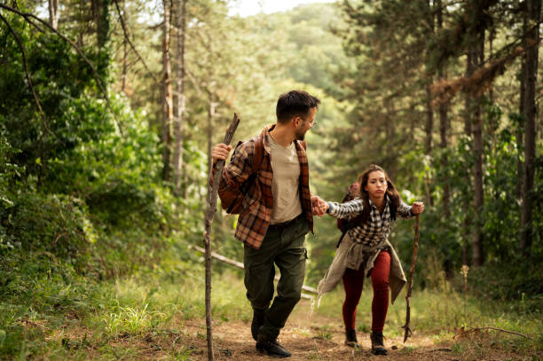 istock Young couple walking through the forrest and exploring nature 2198965378