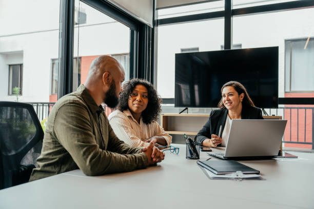Couple talking to real estate agent in office